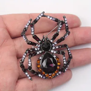 Macro detail of a vintage gothic spider brooch featuring purple and amber rhinestones