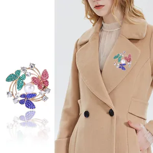 Elegante spilla a farfalla colorata con cristalli e perla mostrata su una modella
