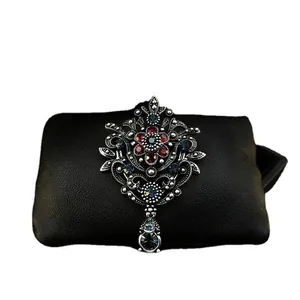 Elegant vintage royal crown brooch featuring red and blue rhinestones on black leather