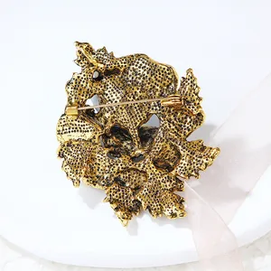 Detail view showing the textured golden back and safety pin of a luxury brooch.