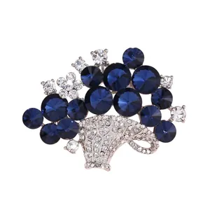 Elegant crystal flower basket brooch featuring deep blue faceted rhinestones and silver finish