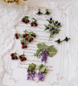 Vintage forest-style purple grape and berry jewelry set shown on decorative paper