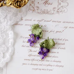 Vintage Mori style purple grape cluster earrings with green leaves and gold accents.
