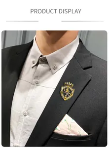 Nahaufnahme einer goldenen Vintage-Löwenschild-Brosche mit Kristallen auf einem schwarzen Revers