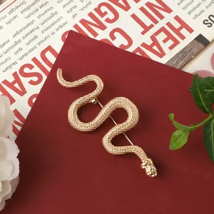 Close-up detail of vintage Baroque style gold snake brooch with textured scale pattern