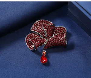 Detailed macro view of an elegant red rhinestone flower brooch with teardrop pendant