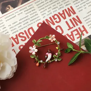 Detail view of a vintage baroque style brooch with enamel flowers and bird motif