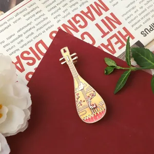 Detailed view of a vintage Pipa-shaped brooch with deer and lotus enamel design