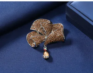 Macro detail view of a vintage flower brooch with brown rhinestones and crystal drop.