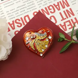 Detailed macro view of vintage Baroque heart-shaped brooch featuring an ornate angel design