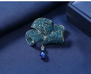 Close-up of elegant blue rhinestone bow brooch with dangling teardrop crystal