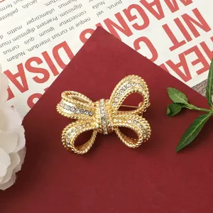 Close-up of a vintage golden bow-knot brooch with sparkling rhinestones.