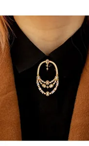 Broche ajourée de style méditerranéen avec cristaux portée sur un col de chemise noire