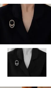 Gros plan d'une broche ajourée de style méditerranéen vintage sur un manteau noir