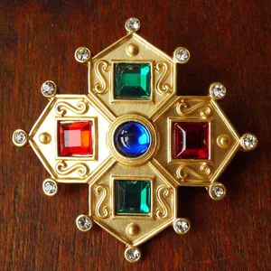 Detailed view of vintage Baroque style brooch with colorful gemstones on gold base