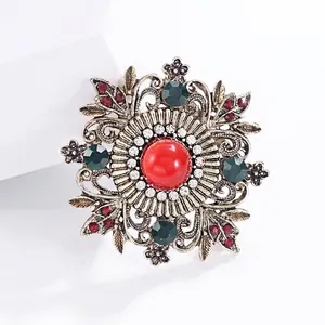 Elegant vintage style brooch featuring a large red center gem and floral alloy carvings
