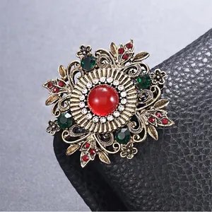 Vue détaillée d'une broche en alliage de style palais vintage avec gemme rouge et strass