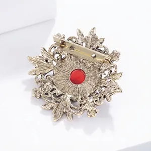 Antique gold-tone vintage style metal brooch with a red center stone back view details