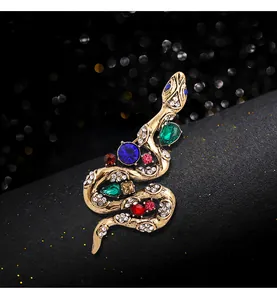 Macro detail of vintage gold snake brooch featuring vibrant colorful gemstones and crystals