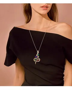 Macro detail of a vintage gold snake pendant necklace with colorful gems on model's neck
