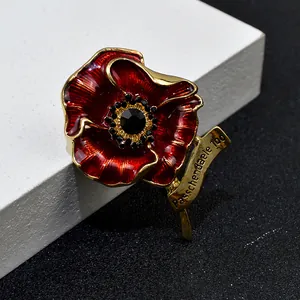 Detalle macro exquisito de broche de amapola de esmalte rojo con centro de cristal negro y oro