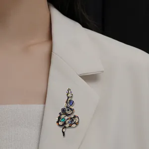 Vintage snake brooch with colorful crystals and enamel decoration on a white blazer.