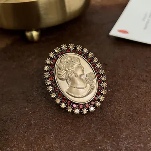 Primo piano dettagliato di spilla a cammeo barocca vintage con strass rossi e dorati