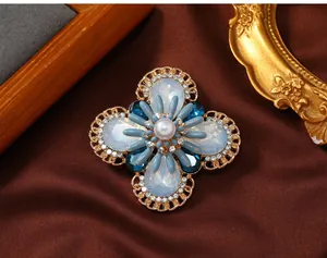 Detailed macro view of a vintage flower brooch with blue opal stones and pearl center