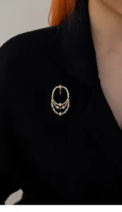 Broche ajourée vintage de style méditerranéen avec cristaux sur un blazer noir élégant