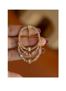 Vue détaillée d'une élégante broche vintage en or avec cristaux scintillants pendants