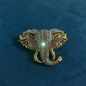 Detailweergave van een vintage gouden olifantspeld met kleurrijke strass-steentjes