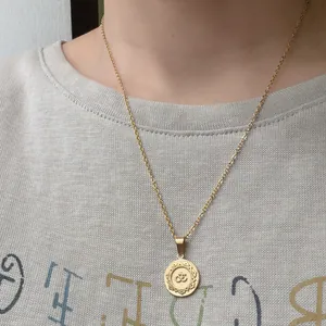 Macro detail of a vintage gold stainless steel necklace with an Om symbol pendant