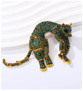Dettagli squisiti di una spilla a leopardo vintage dorata con strass verdi e blu