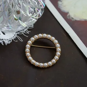 Detailed close-up view of a vintage Baroque style round pearl brooch pin for women.