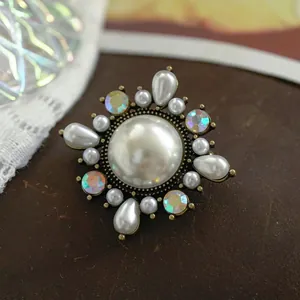 Detailed view of a vintage Baroque pearl brooch with iridescent rhinestones and matte finish.