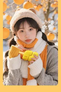 Cute little yellow duck magnetic portable hand warmer being held by a girl outdoors in winter