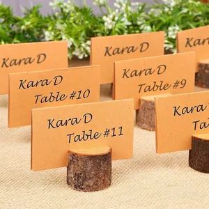 Primer plano de soportes de madera rústica para tarjetas de mesa con papel kraft decorativo