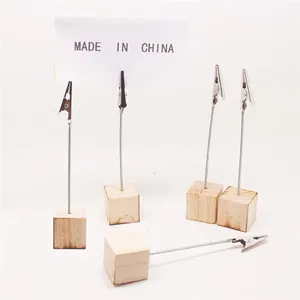 Detail van vijf memoclips met houten basis voor tafelnummers en kleine visitekaartjes.