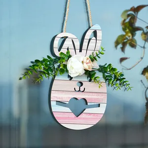 Détail d'un lapin de Pâques en bois à suspendre avec fleurs sur une surface en verre