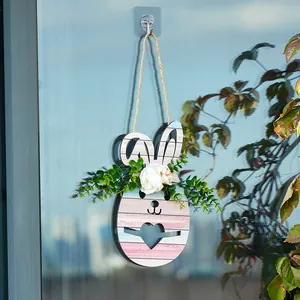 Gros plan d'une décoration de porte en bois de lapin de Pâques avec fleurs artificielles