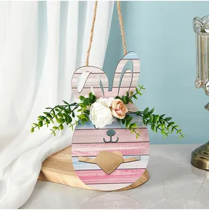 Vue détaillée d'un panneau suspendu lapin de Pâques en bois avec fleurs et découpe de cœur.