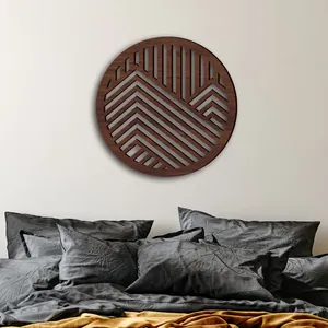 Vista detallada de una decoración de pared circular de madera con diseño de montañas.