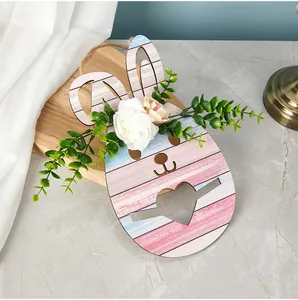 Détail d'une plaque de lapin de Pâques en bois avec fleurs artificielles et feuilles.
