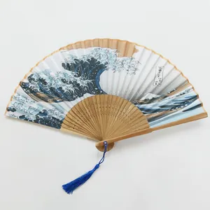 Vista detallada del abanico plegable de bambú con estampado Gran Ola y borla azul clara