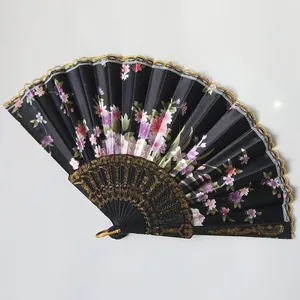Elegant black satin folding fan with purple floral print and gold lace trim detail.