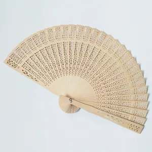 Close-up detail of an intricate laser-cut floral pattern on a natural wooden folding fan