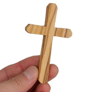 Exquisite handmade olive wood cross pendant necklace shown held in hand for scale