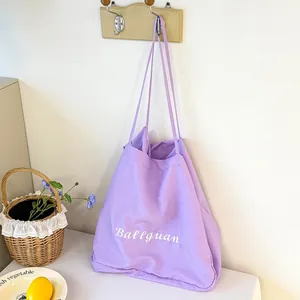 Minimalist large capacity purple fabric tote bag hanging on a hook in a home setting.