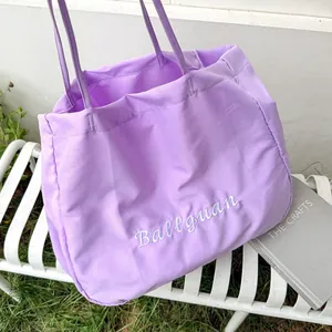 Detail view of a large capacity purple fabric tote bag placed on a garden bench
