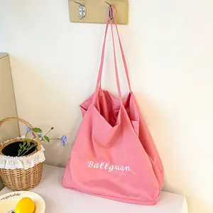 Detail of pink canvas tote bag with Ballguan embroidery in minimalist lifestyle scene